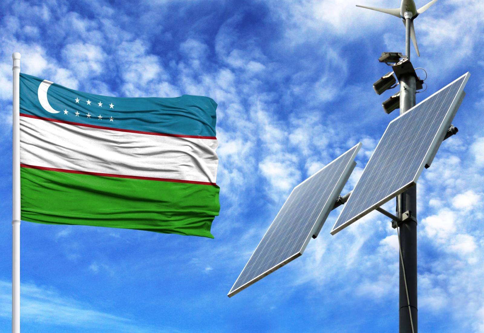 Solar panels on a background of blue sky with a flagpole and the flag of Uzbekistan